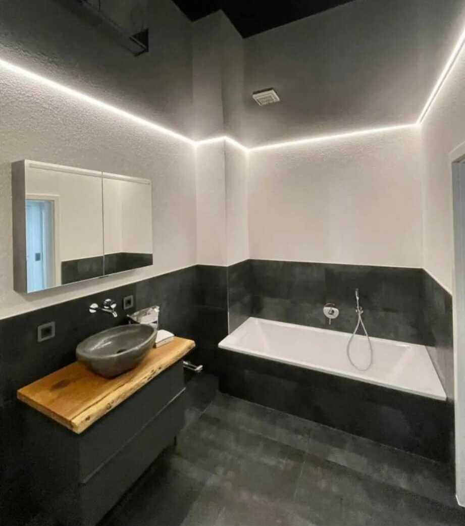 Schwarze Hochglanz-Spanndecke im modernen Badezimmer mit LED-Voute